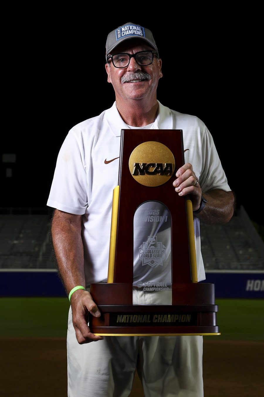 Mike White holding an NCAA championship trophy